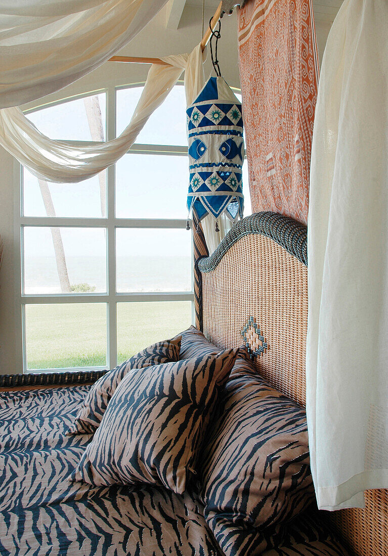 Four poster bed with swathes of fabric and animal print bed linen