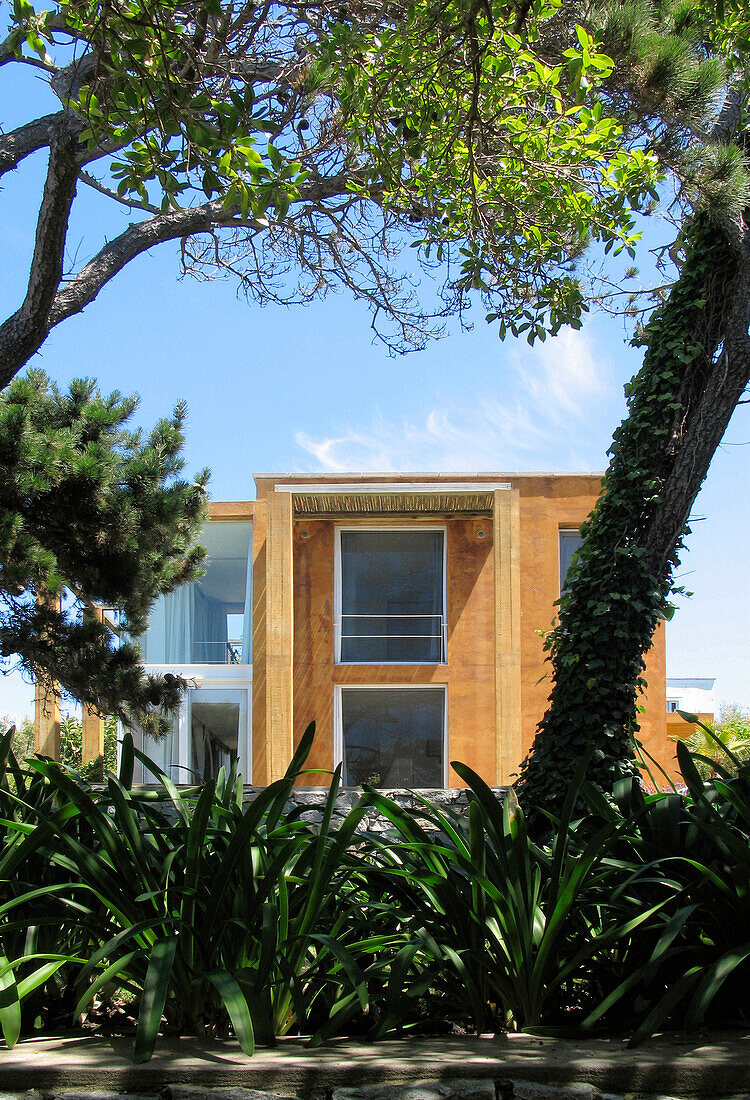 Beach house exterior set in garden with shady trees