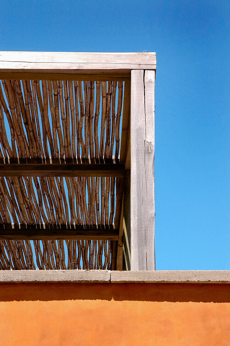 Wooden pergola set against blue sky