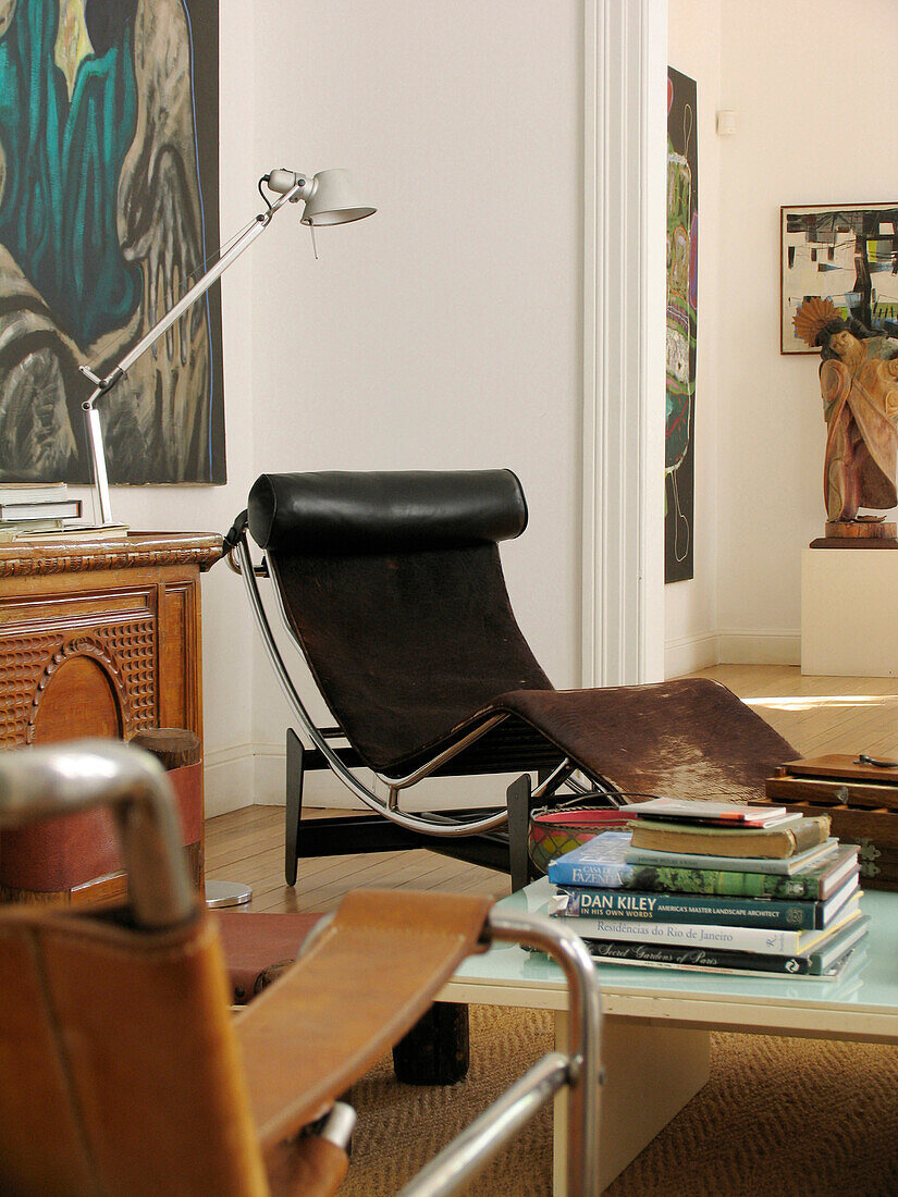 Schwarzer Lehnstuhl mit Sideboard und Büchern auf Couchtisch