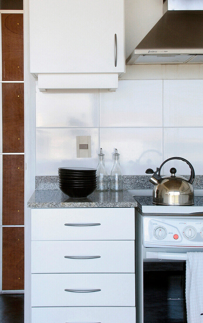 Silver kettle on hob with bowls on kitchen worktop