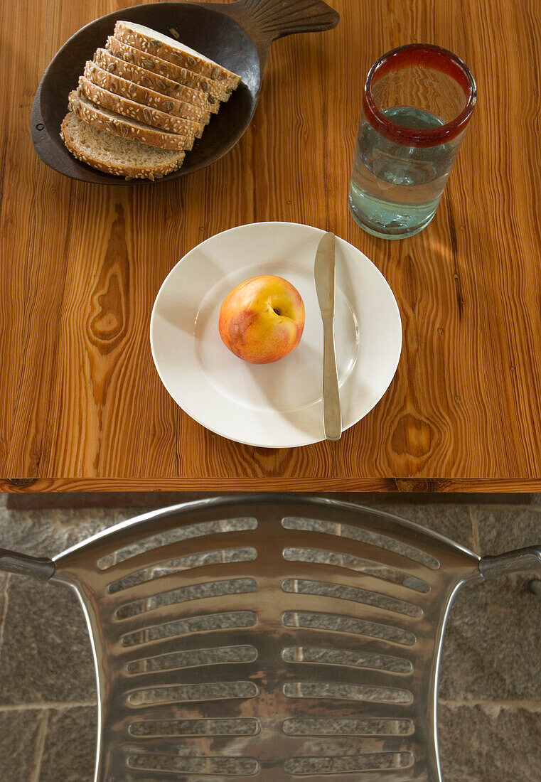 Apple on plate with knife sliced bread and a glass of water