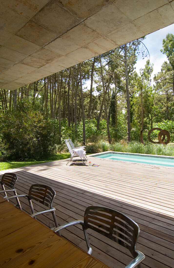 Poolterrasse mit Stühlen in einem Waldstück