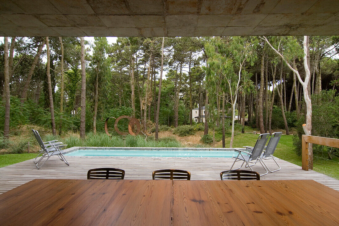 Man walking on poolside decking talks on mobile phone