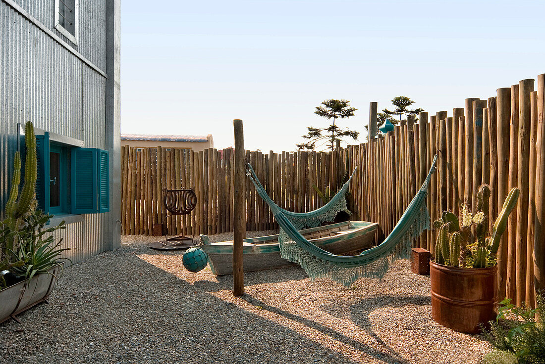 Pinewood fenced garden with a fisherman boat and Paraguayan hammocks