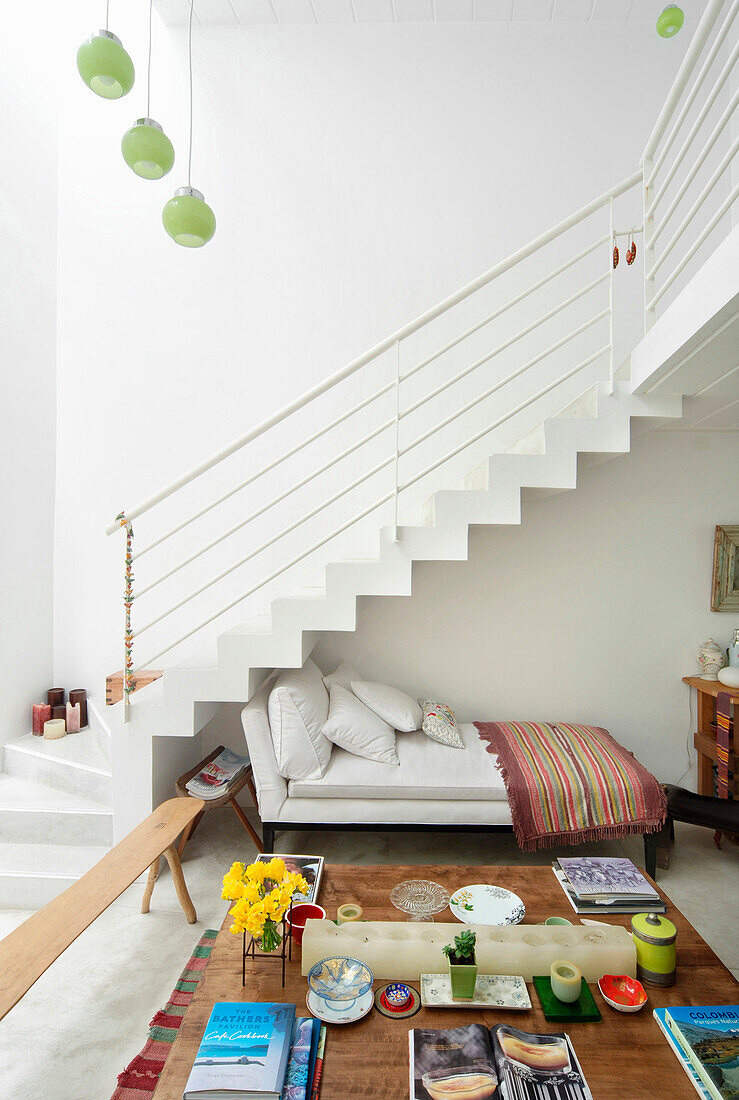 White day bed with floral cushion and striped rug