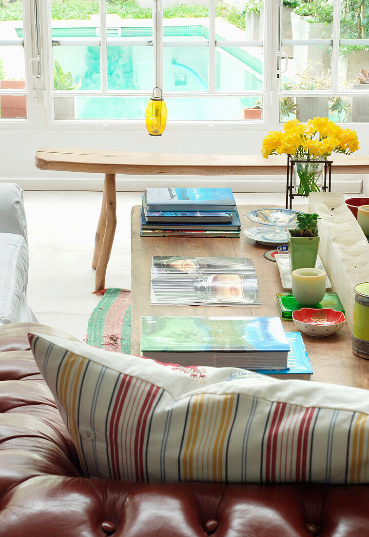 White day bed with floral cushion and striped rug