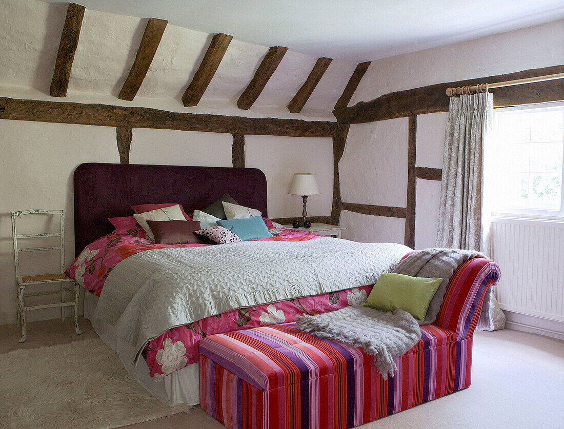 Doppelbett mit gestreiftem Tagesbett in einem Haus mit Balken aus dem 17. Jahrhundert in Oxfordshire