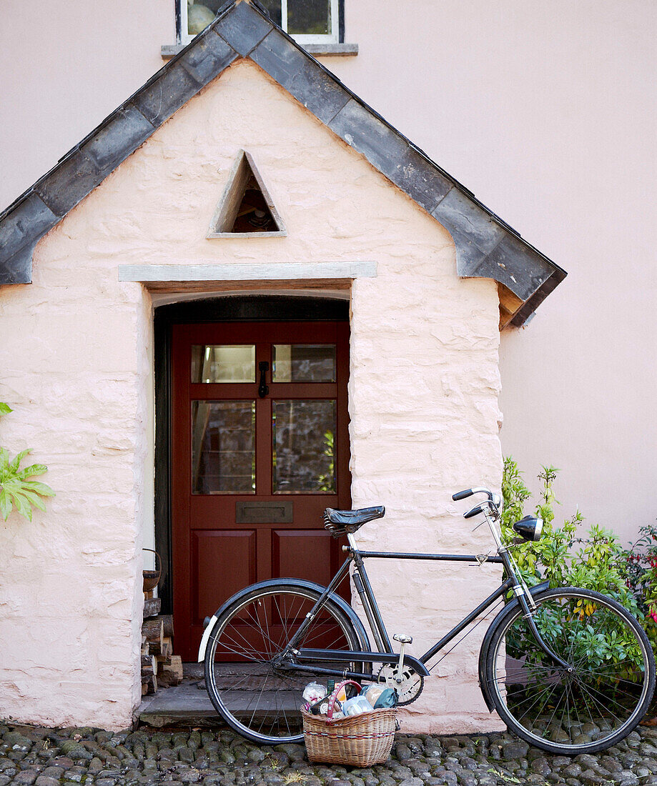 Bicycle parked at porch with pitched roof