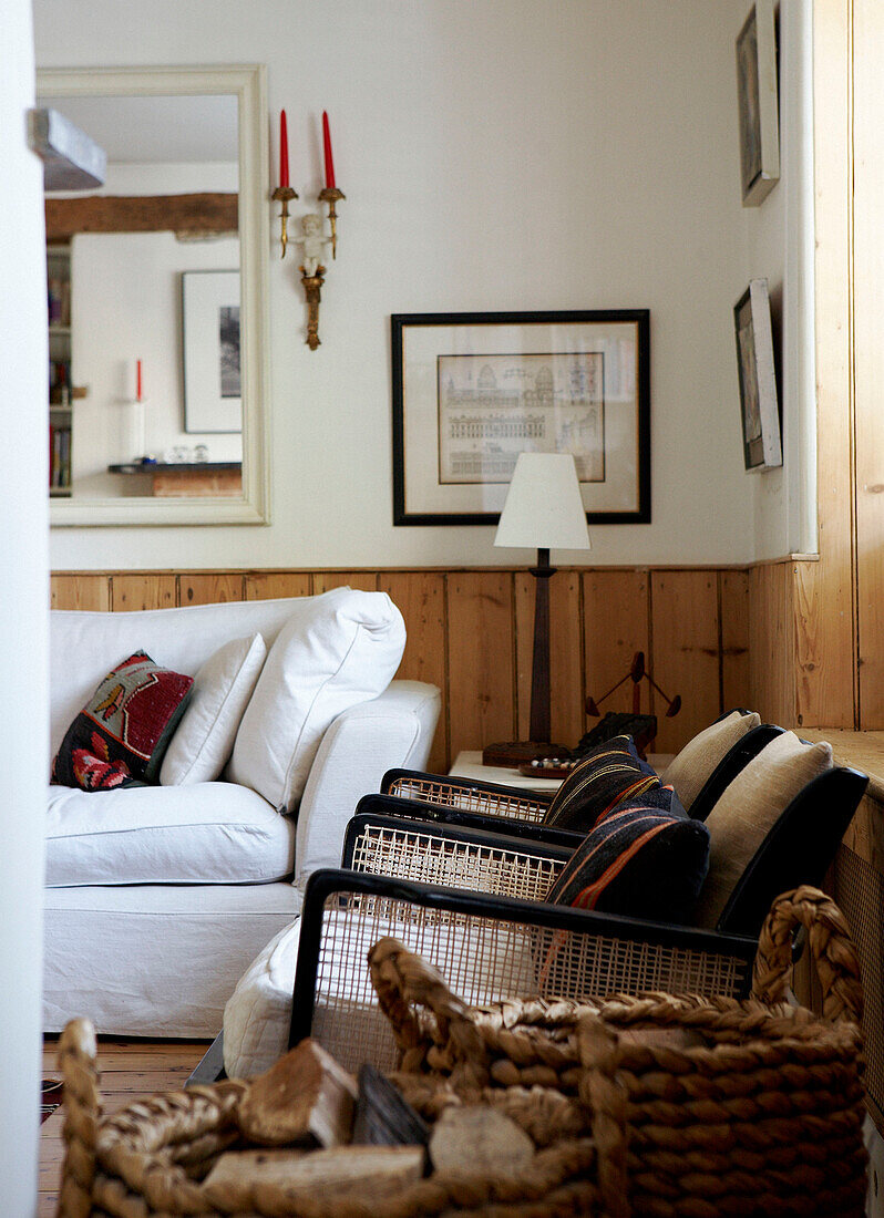 Matching chairs and log basket below window of 1820s house