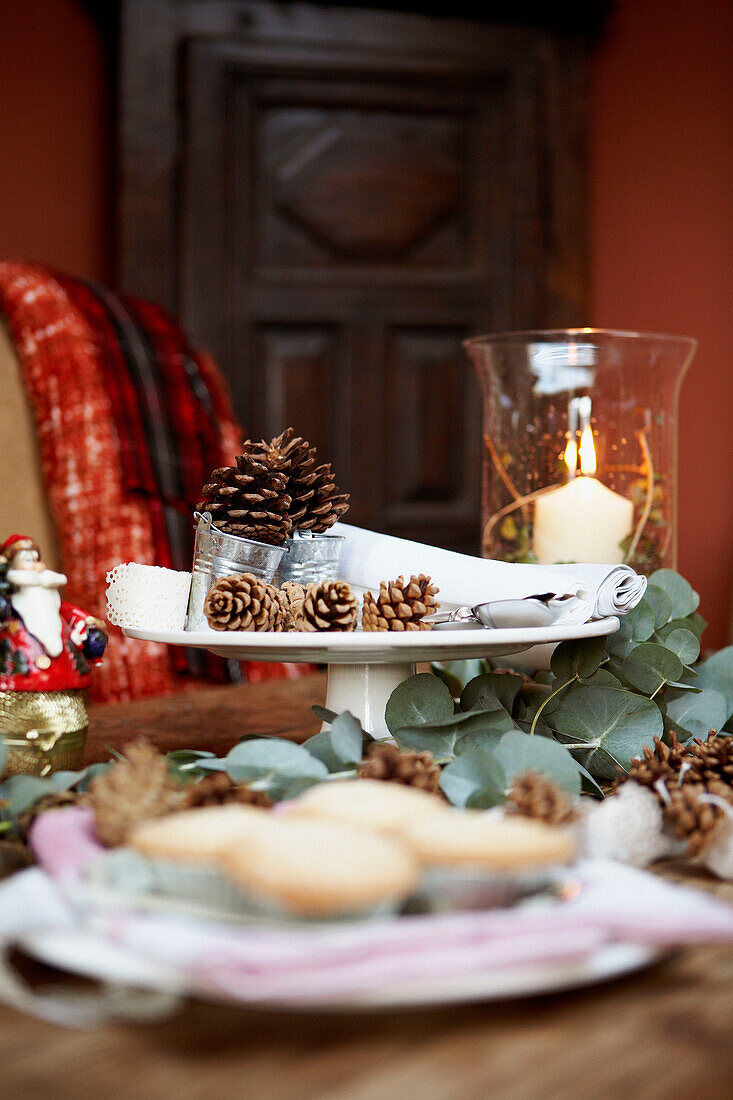 Mince pies and pine cones on Christmas cake stand