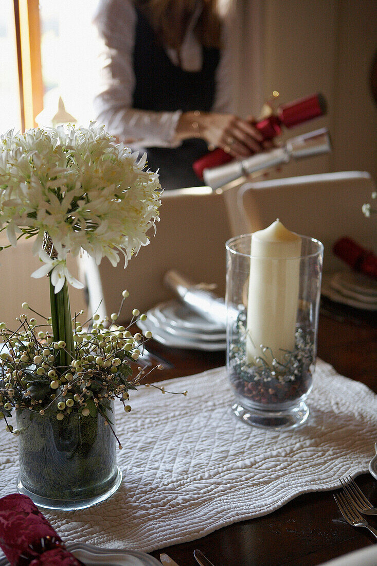 Woman placing crackers on table with floral centre piece 
