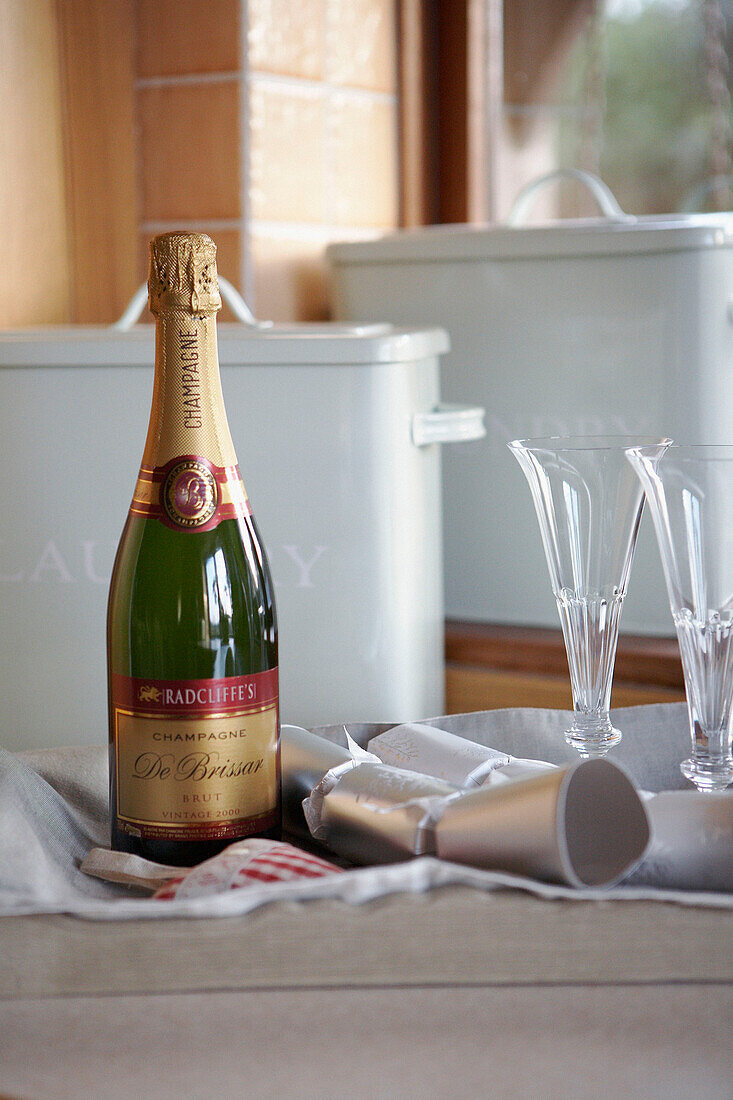 Champagne bottle and glasses on a tray with silver crackers