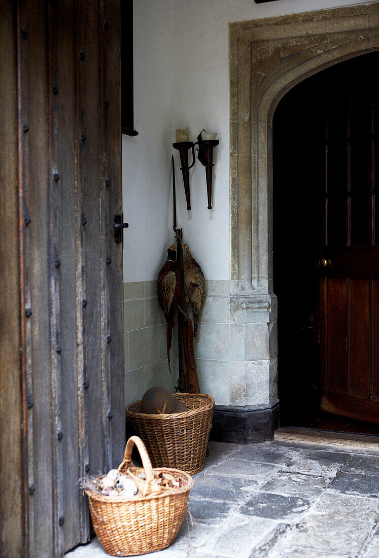 Fasane hängen mit einem Gewehr in der Veranda eines unter Denkmalschutz stehenden elisabethanischen Herrenhauses in Kent