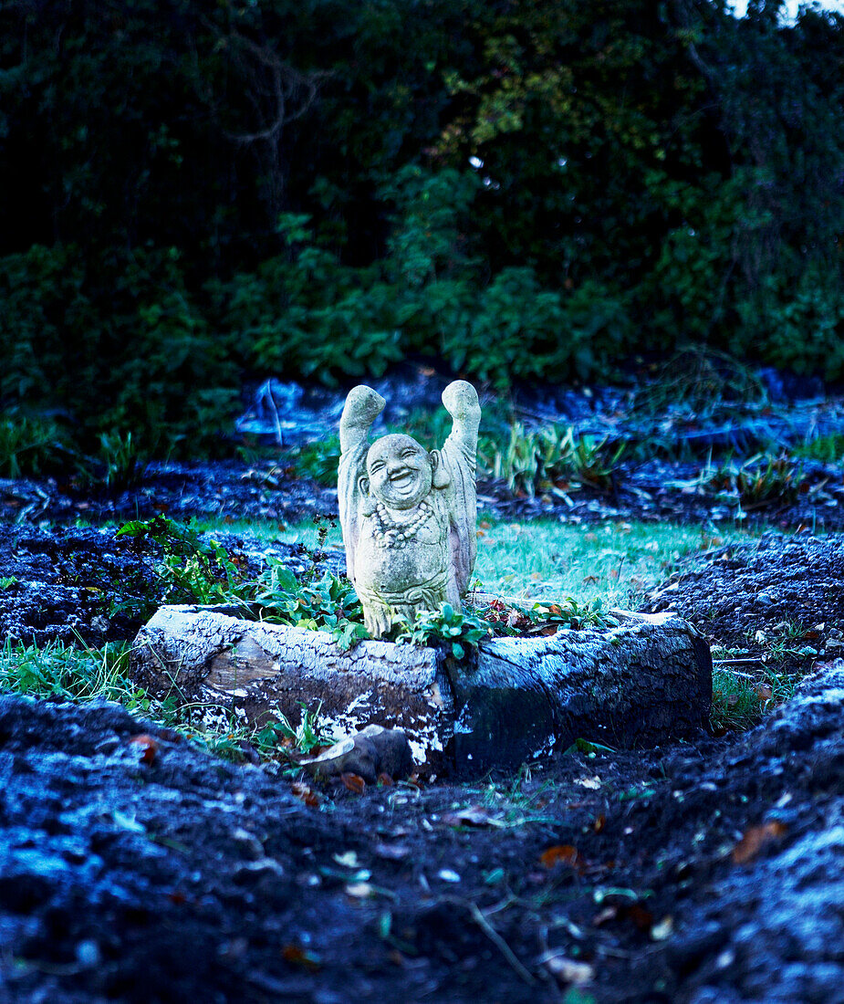 Buddha-Statue im Gemüsegarten mit Winterfrost