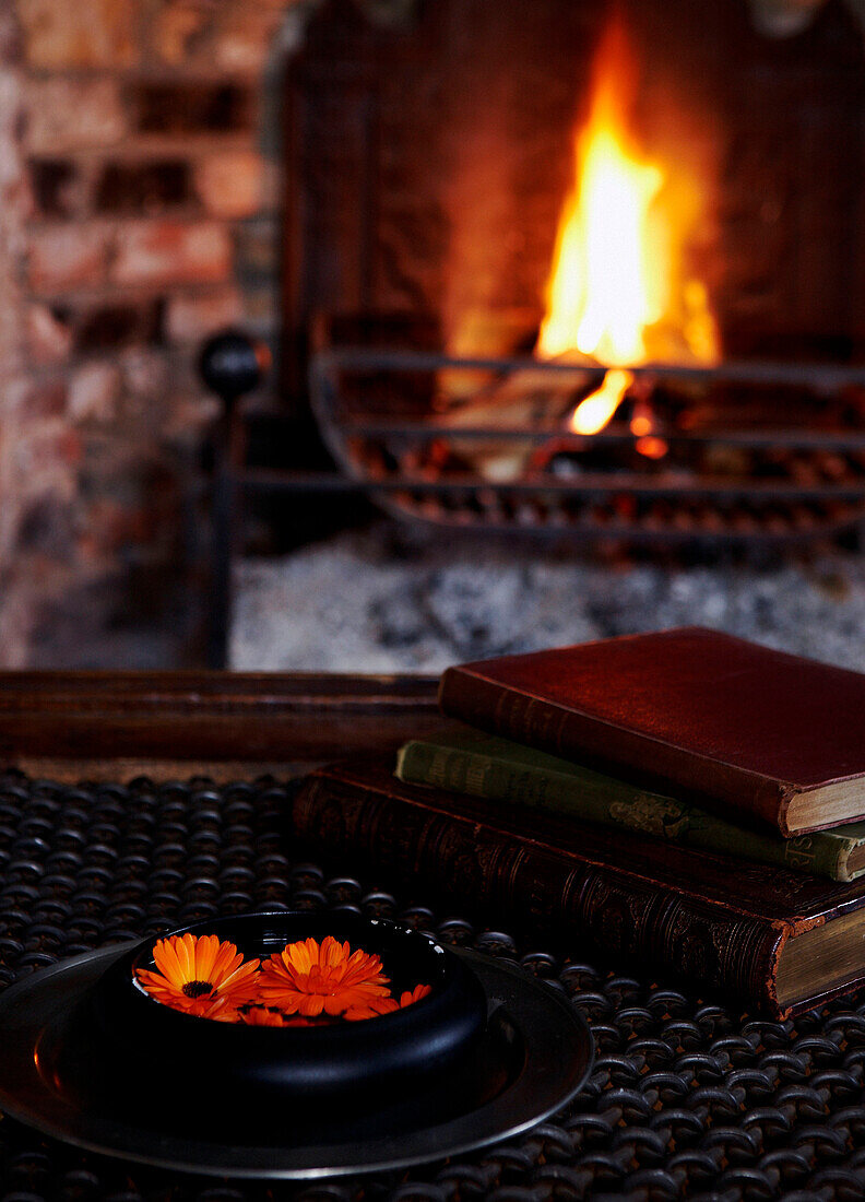 Bücher auf dem Couchtisch mit offenem Kamin in einem georgianischen Bauernhaus