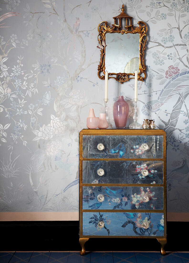 Oriental design on chest of drawers below gilt framed mirror