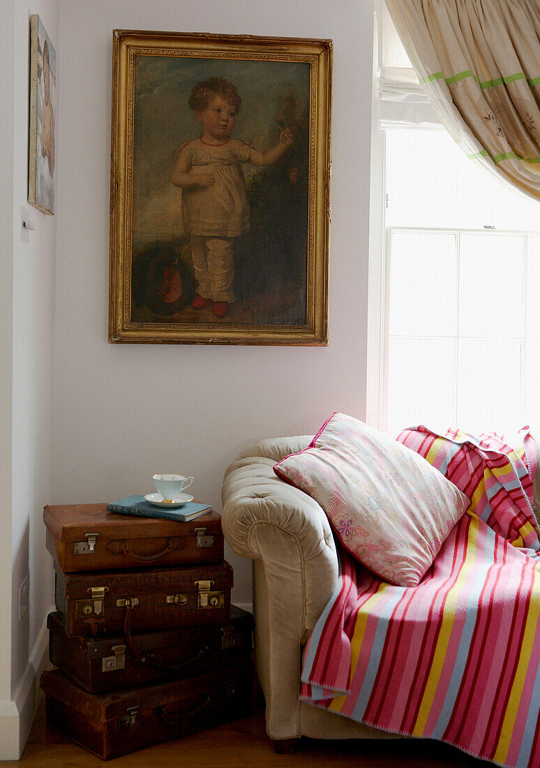 Gestreifte Decke auf dem Sofa unter dem sonnenbeschienenen Fenster einer georgianischen Terrasse aus dem 18. Jahrhundert in Hampstead, London