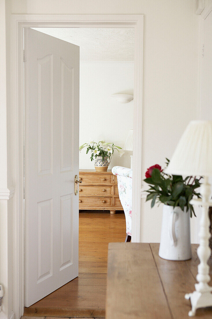 Blick durch die offene Tür eines Landhauses mit hölzernen Sideboards