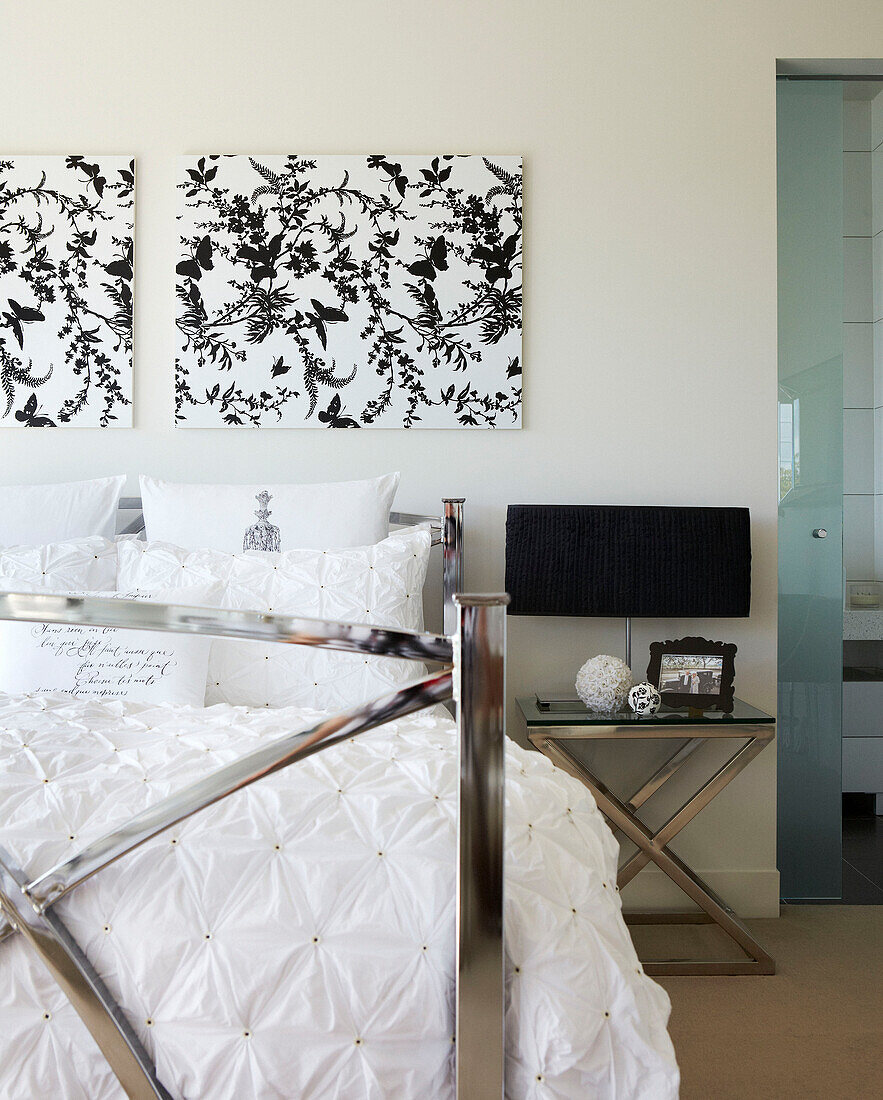 Metal framed bed with black and white artwork