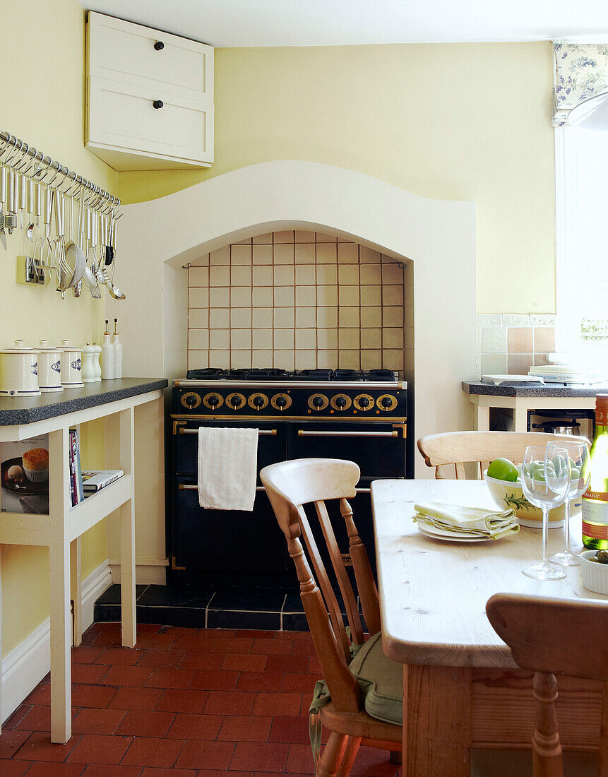 Wall mounted corner cupboard above range oven in tiled kitchen