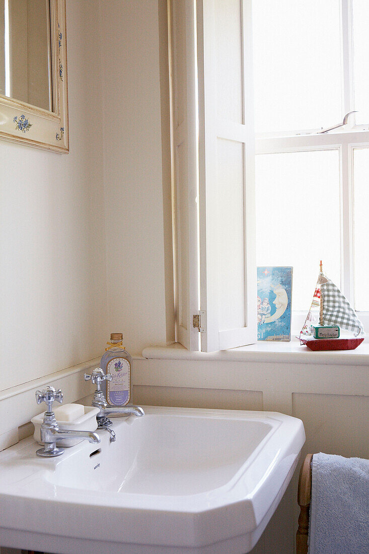 Model boat on windowsill beside bathroom sink