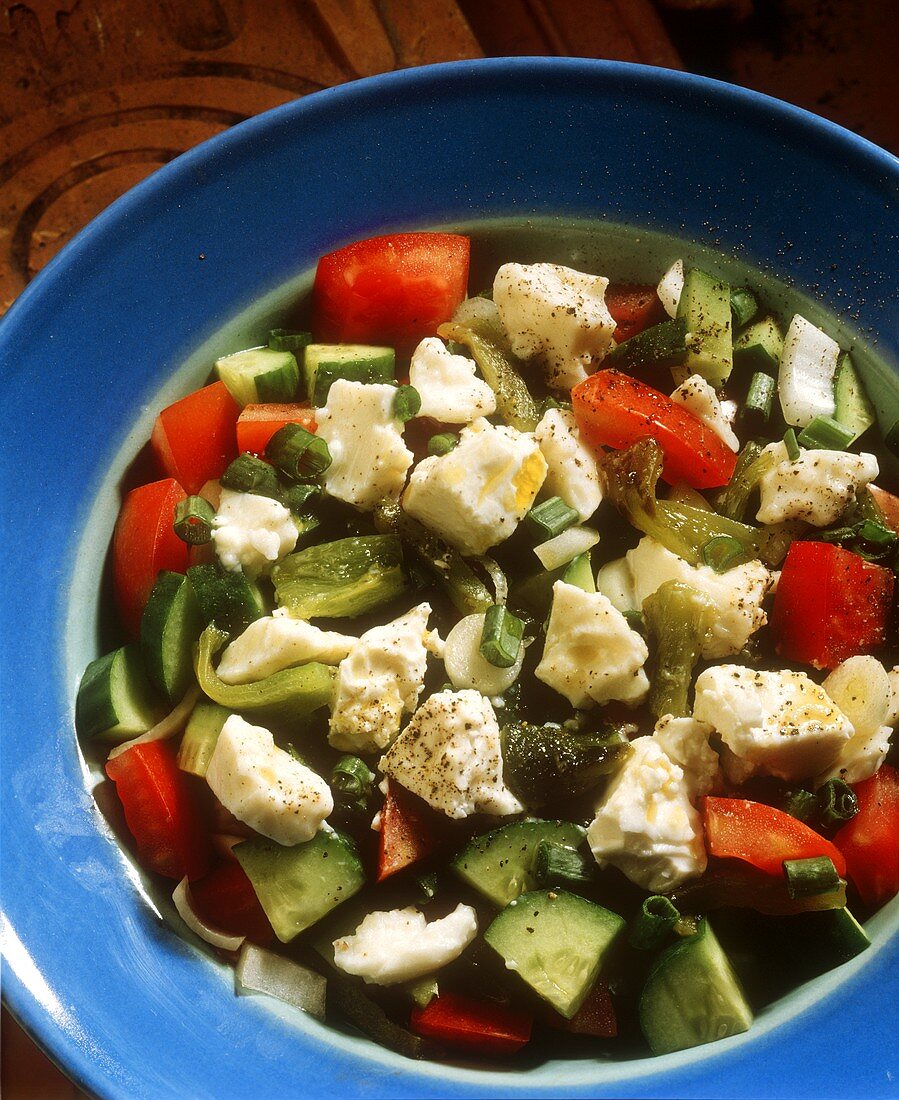 Vegetable salad with sheep's cheese in deep plate