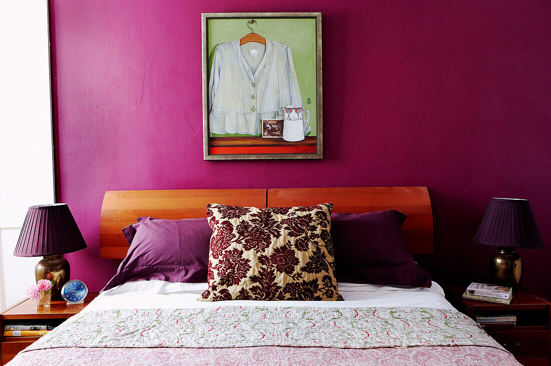 Artwork above bed with floral patterned cushion