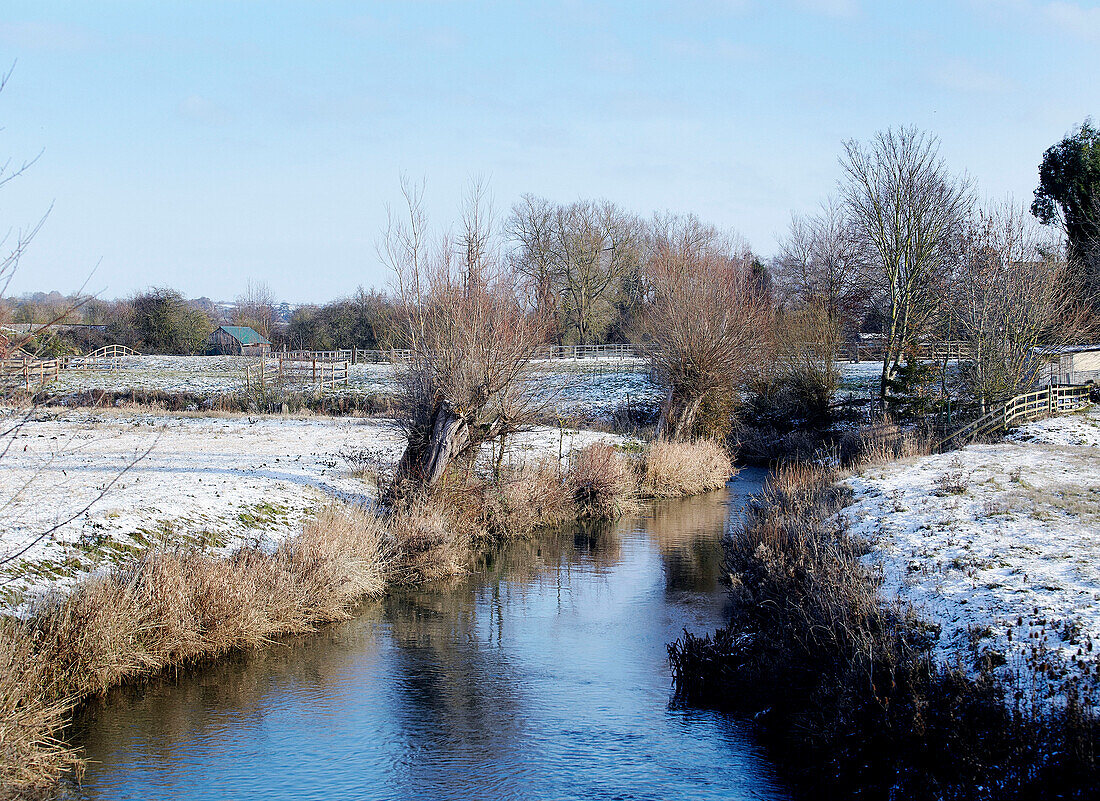 Stream flows through winter landscape