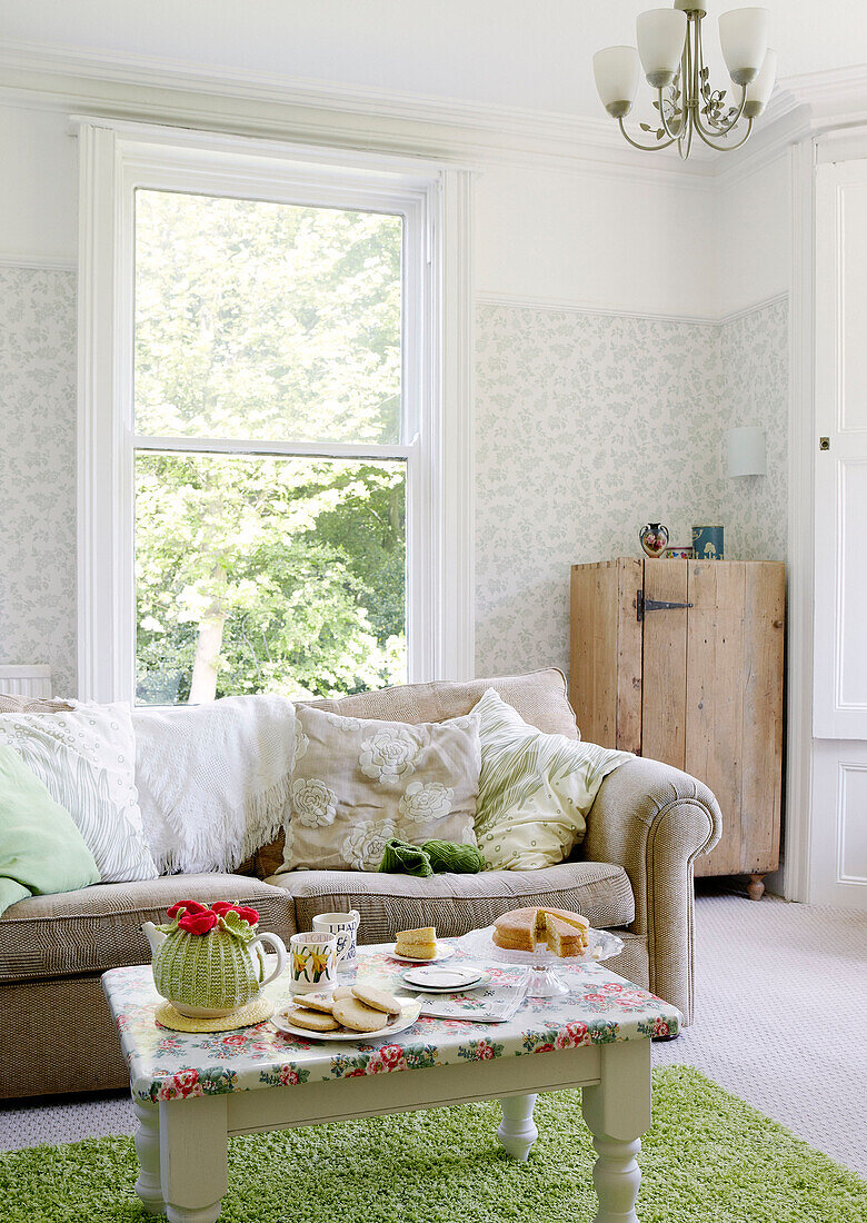 Afternoon tea set in living room with green rug