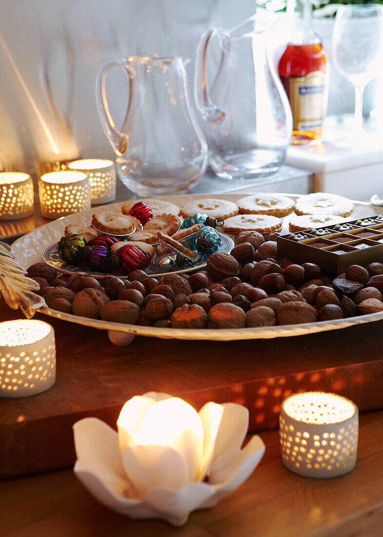 Selection of nuts and mince pies with lit candles