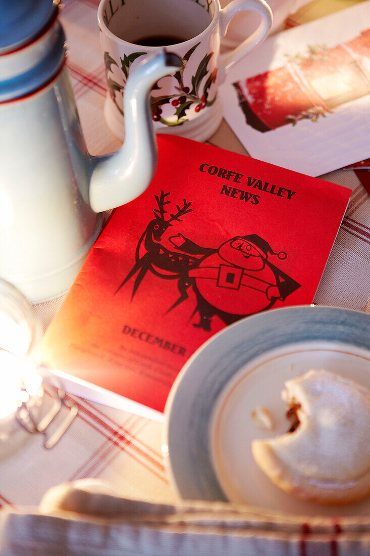 Coffee pot and Christmas news mince pie with a bite taken