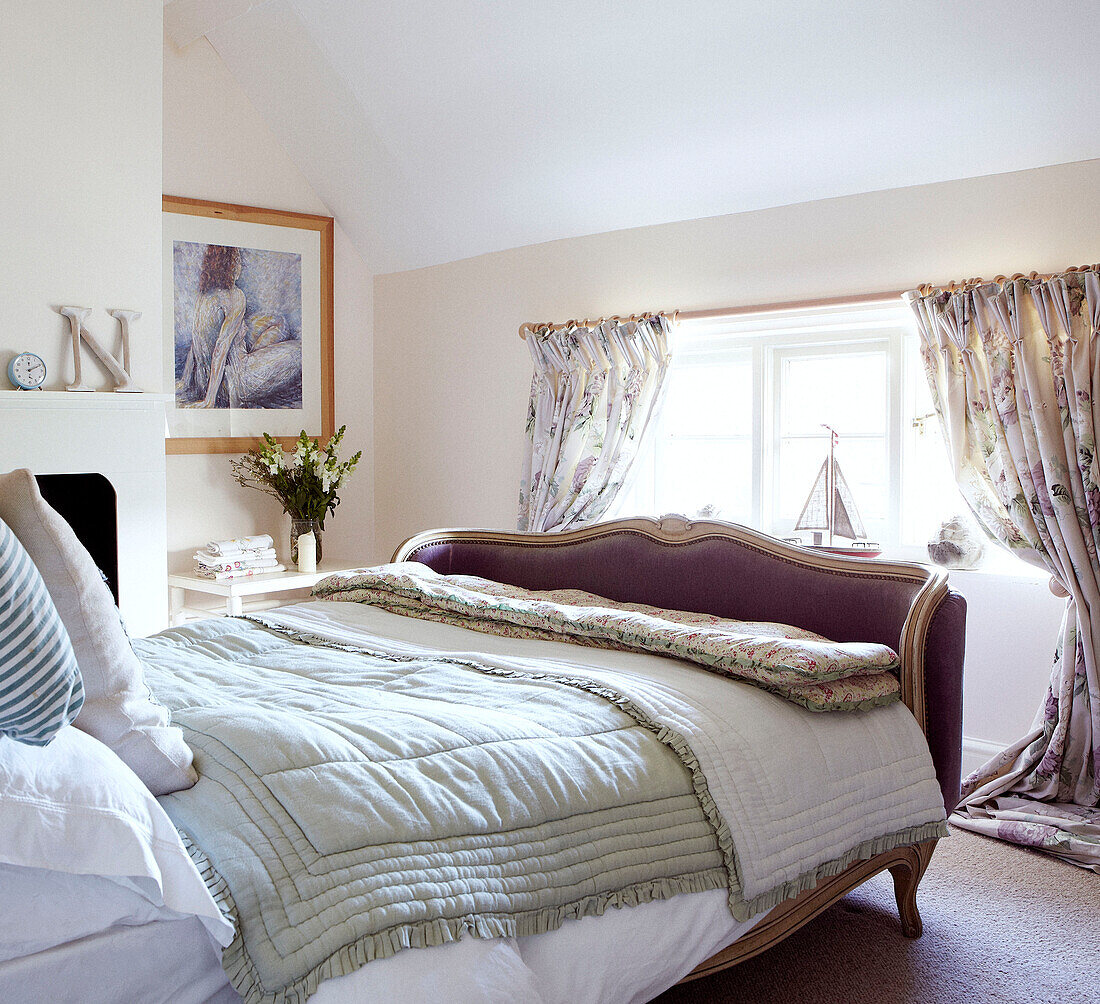 Low window in attic room with quilted bed covers