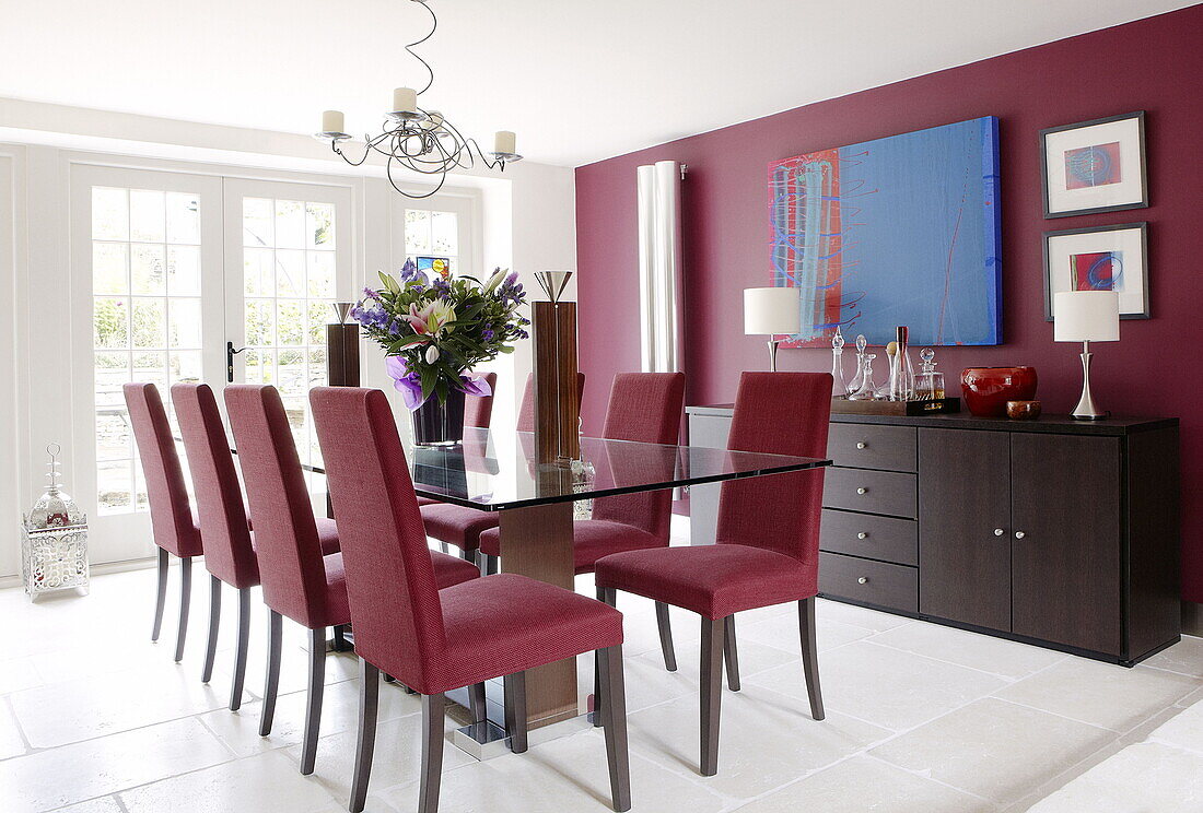 Glass topped table with co-ordinating chairs and wall in renovated Cotswolds mill house England UK