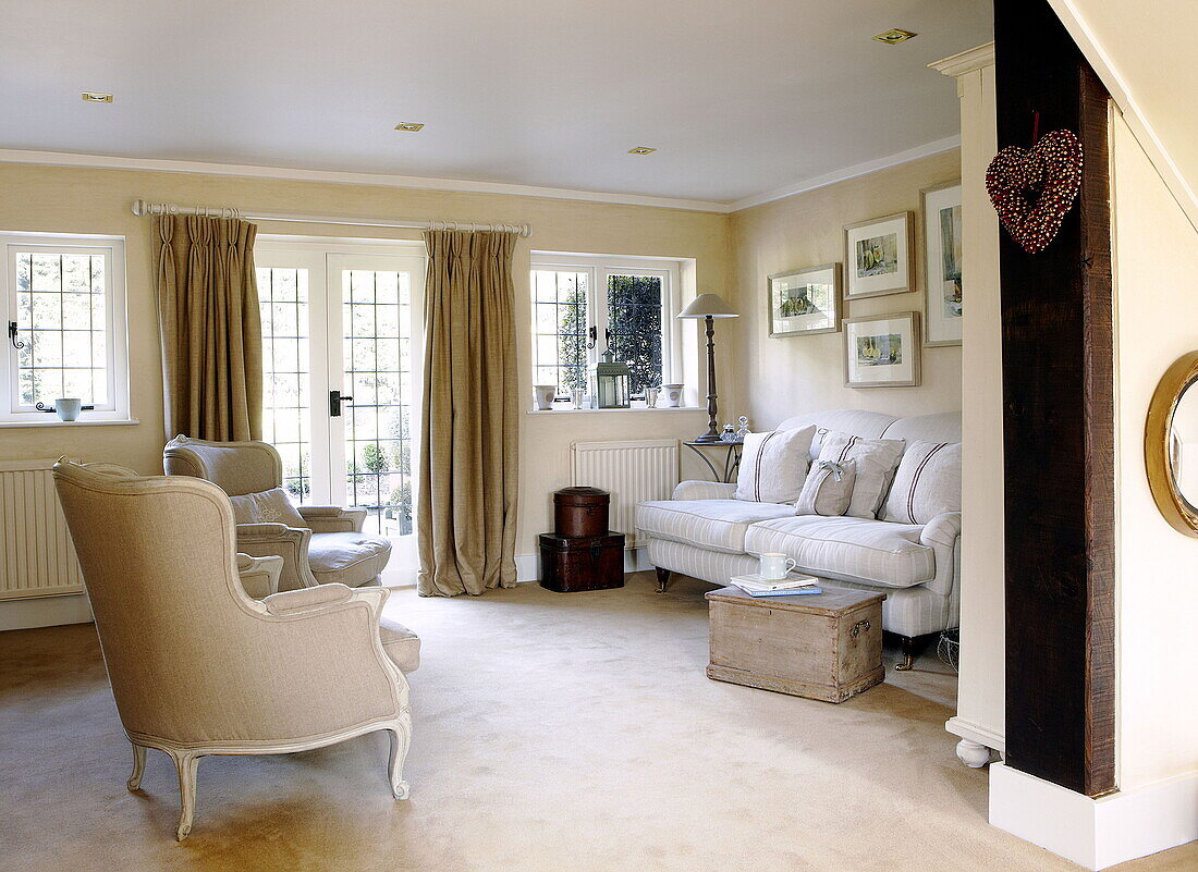 Seating area with curtained doors in living room of Forest Row farmhouse Surrey England UK