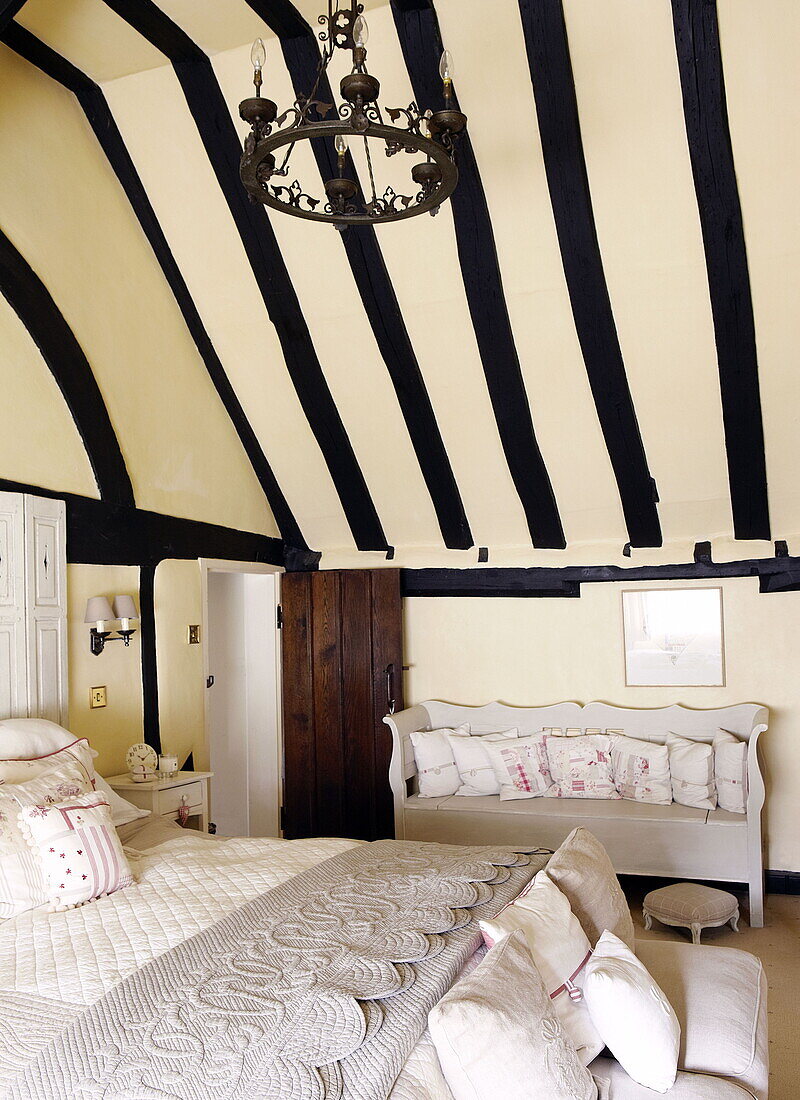 Dramatische Balkendecke im Schlafzimmer eines Bauernhauses in Forest Row Surrey England UK