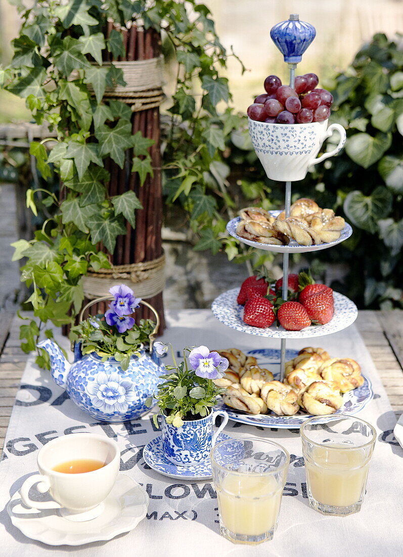 Fruit and pastries on cake stand garden table City of Bath Somerset, England, UK