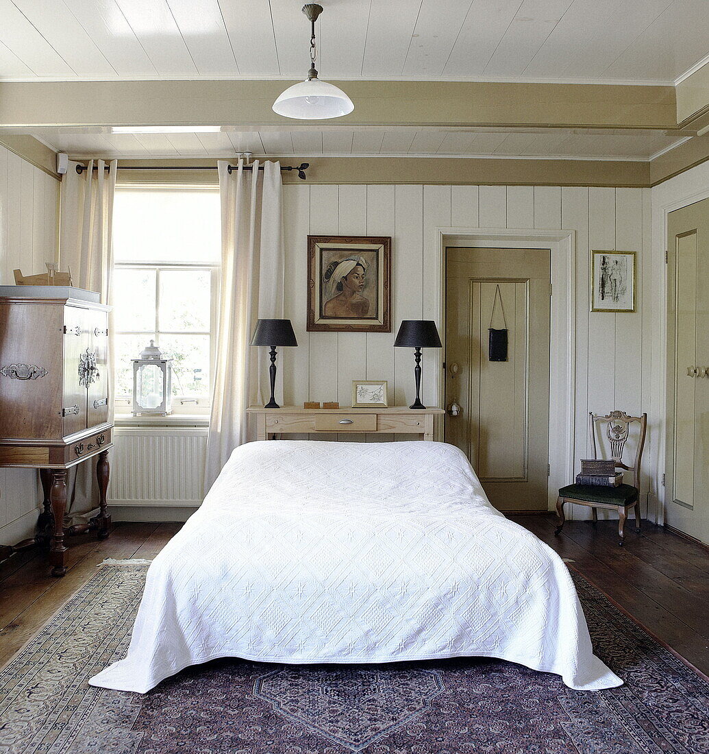 White quilt cover and oriental cabinet in Abbekerk home in the Dutch province of North Holland municipality of Medemblik