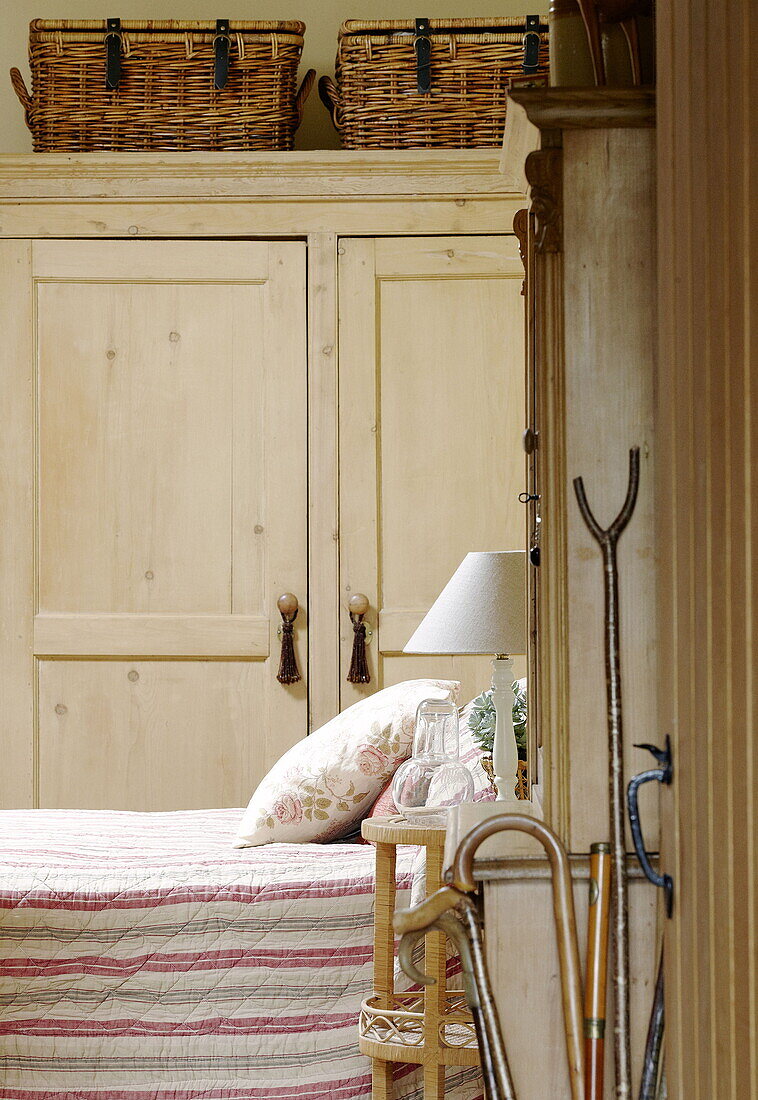 Schlafzimmer Detail mit gestreifter Steppdecke und Aufbewahrungskörben auf Kleiderschrank in Hexham Landhaus Northumberland England UK