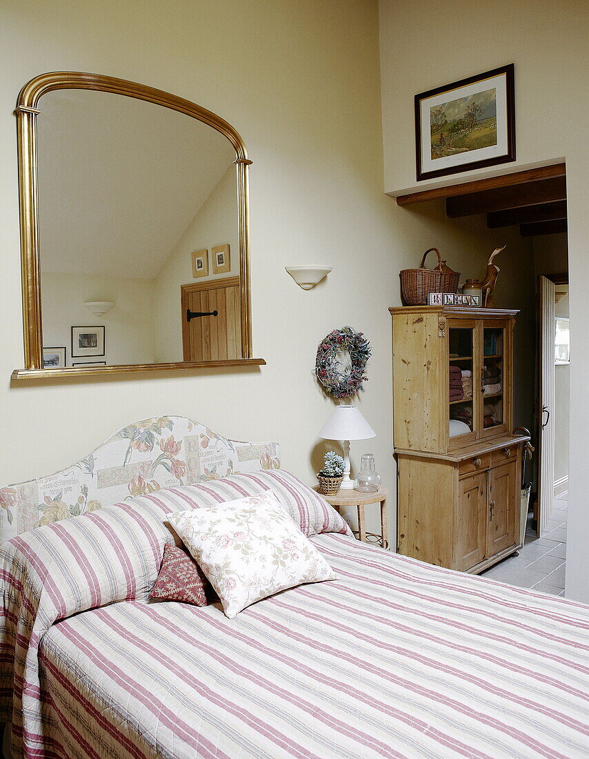 Gilt framed mirror above double bed in Hexham country house Northumberland England UK