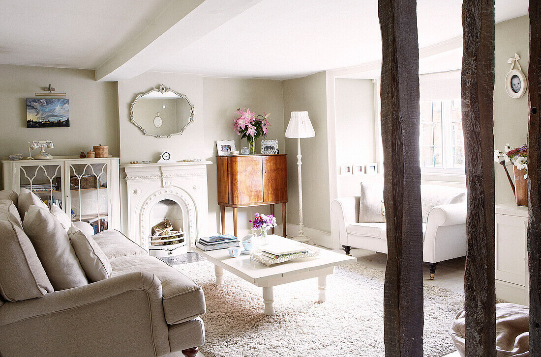 Painted white coffee table with vintage wooden cabinet in living room, Oxfordshire home, England, UK