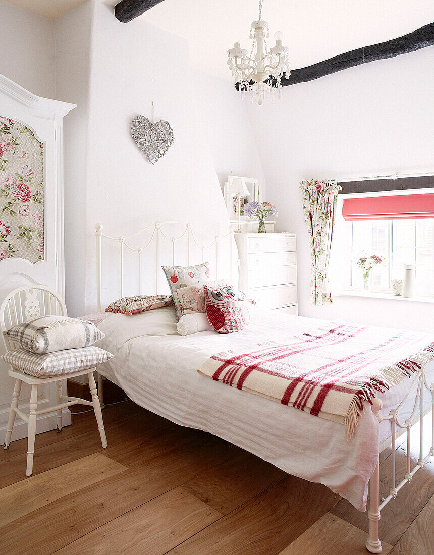 Single bed with red checked blanket in bedroom of Oxfordshire cottage, England, UK