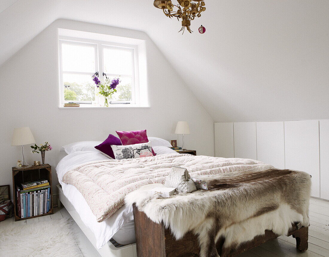 Double bed at uncurtained window with bedside crate in contemporary Oxfordshire cottage, England, UK