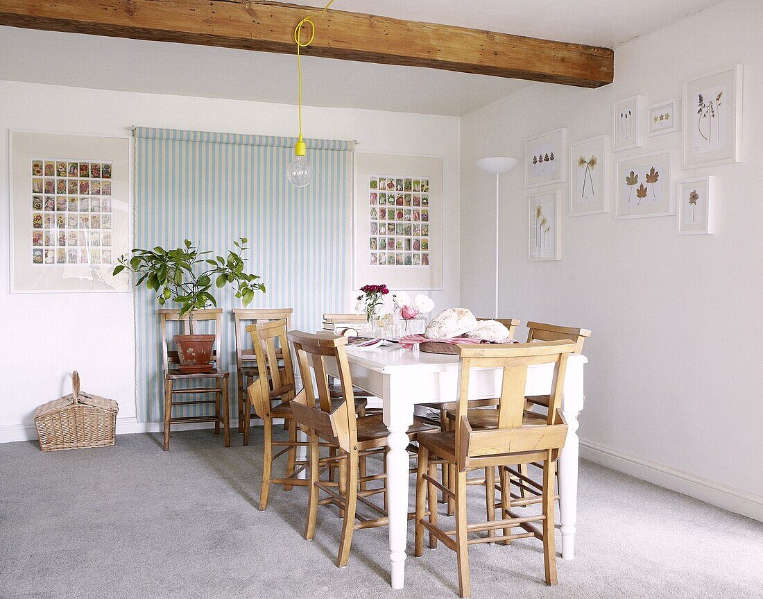 Esstisch mit Kirchenbänken unter dem Deckenbalken eines modernen Cottages in Staffordshire, England, Vereinigtes Königreich