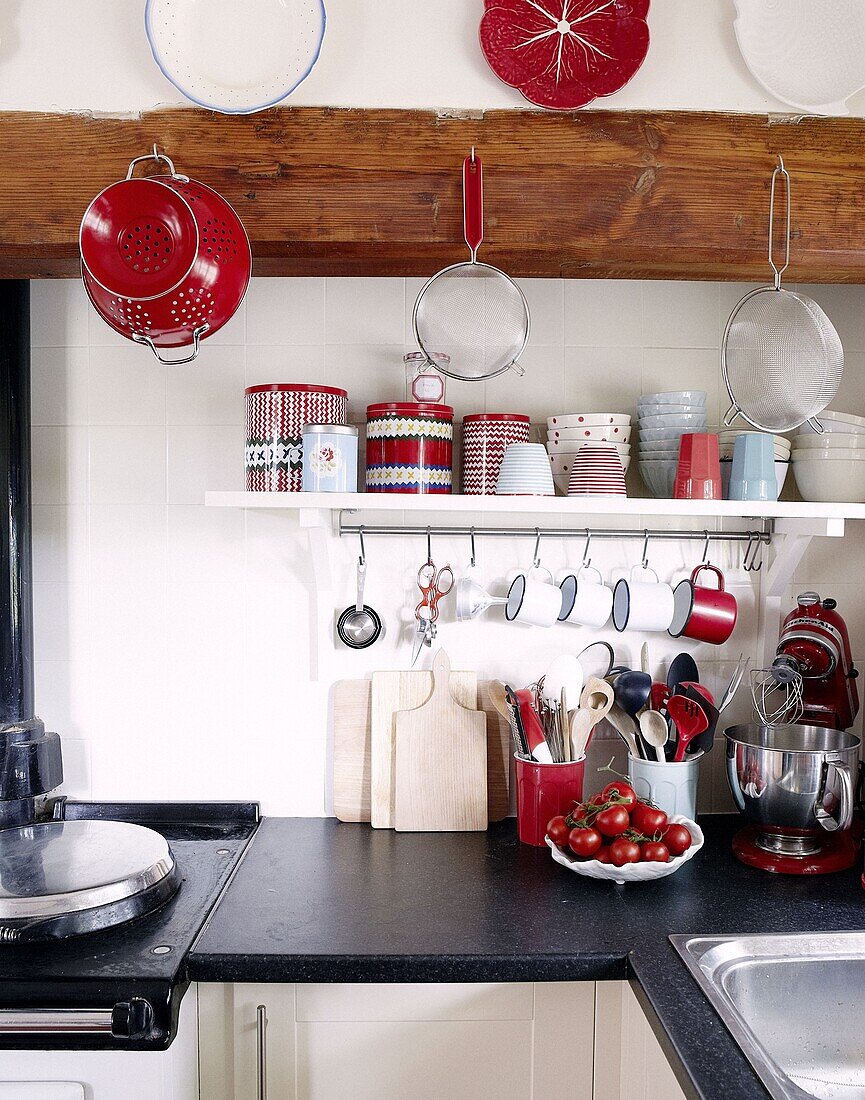 Küchengeräte und Utensilien auf schwarzer Arbeitsplatte in moderner Landhausküche, Staffordshire, England, UK