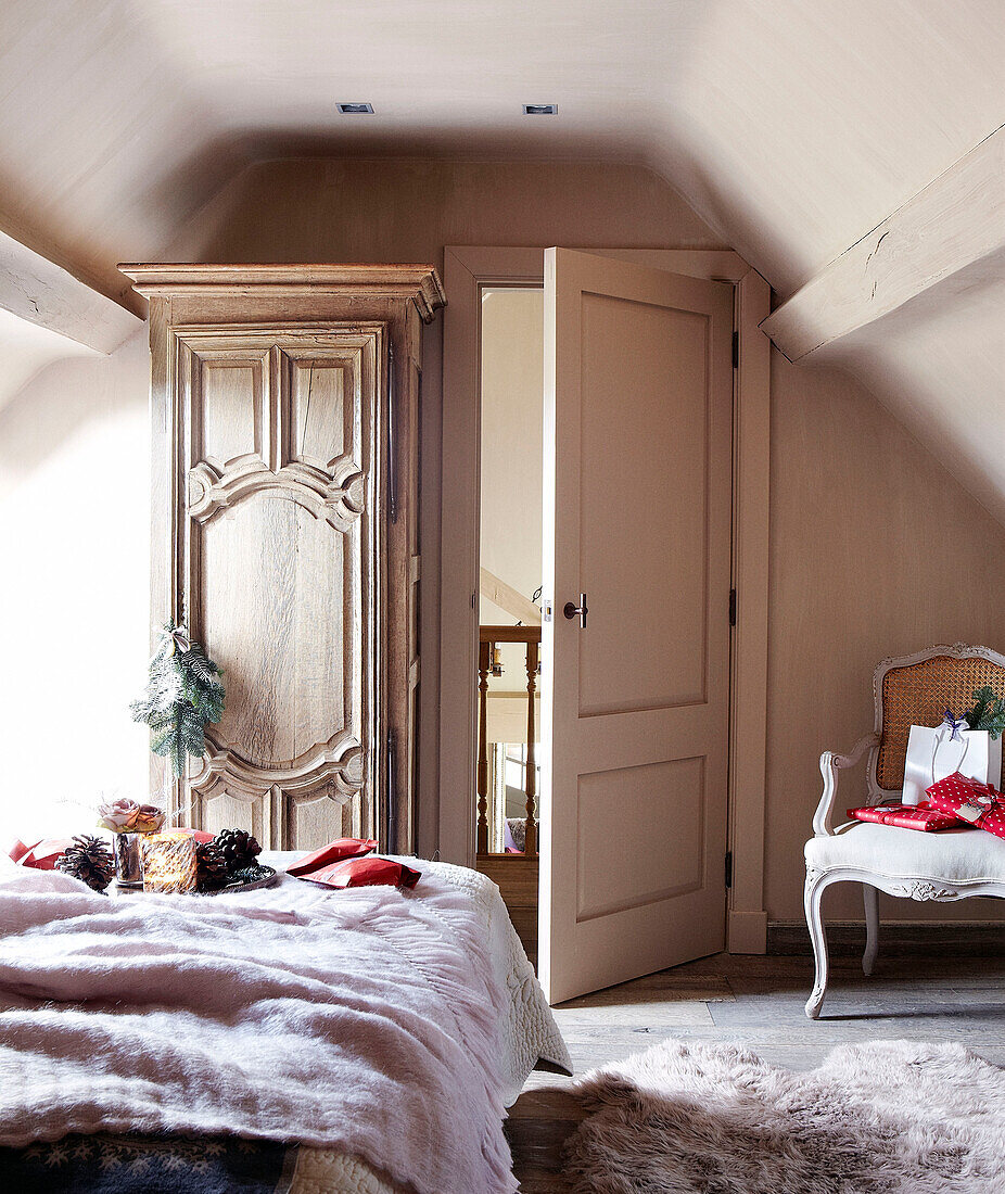 Carved antique wardrobe in attic bedroom of festive Oxfordshire home, England, UK