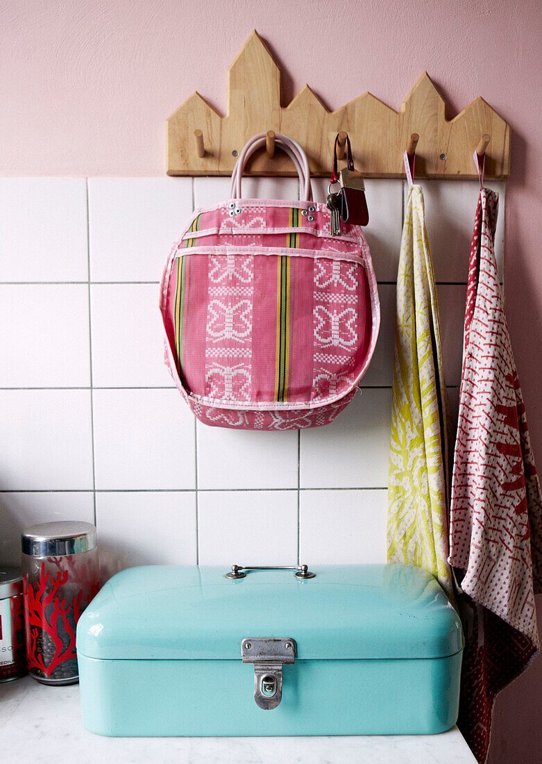 Bag and keys with dishcloths hang on hooks above turquoise safe in kitchen of contemporary apartment, Amsterdam, Netherlands