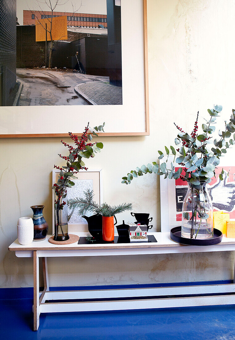 Leaf arrangements in vases on console table London home England UK