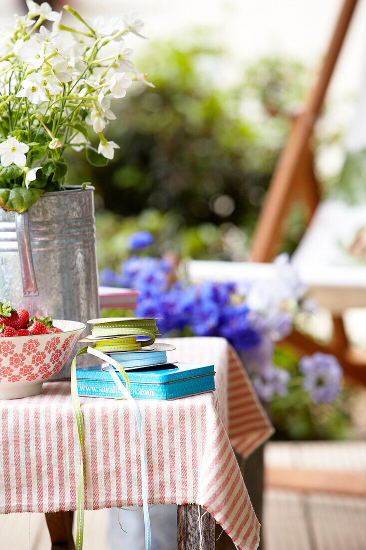 Cut flowers and strawberries on table in Surrey back garden England UK