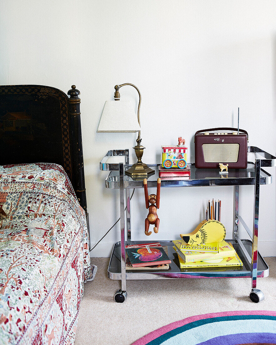 Vintage-Lampe und Radio auf verchromtem Servierwagen als Nachttisch im Jungenzimmer eines Londoner Stadthauses England UK